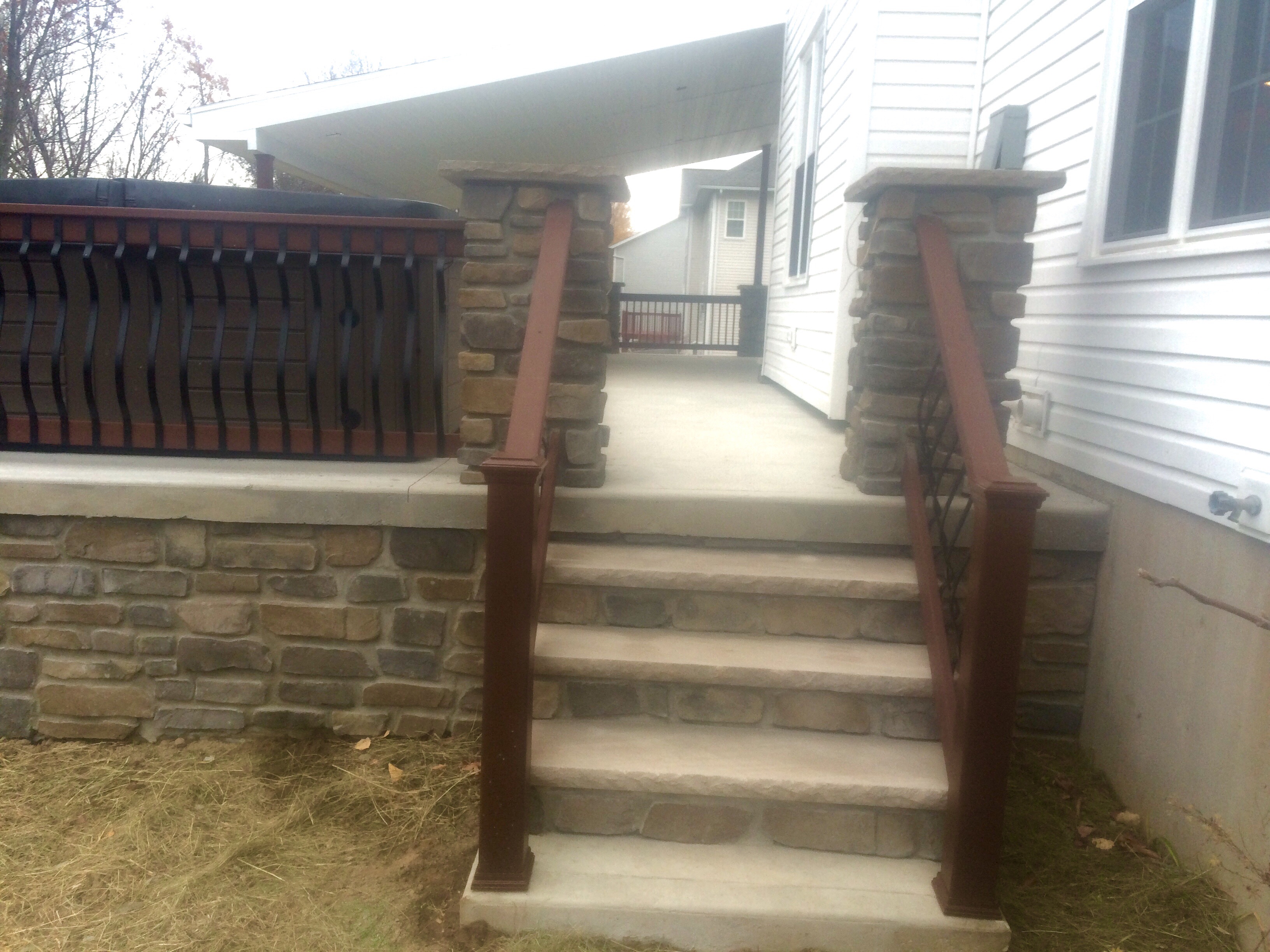 Multi-level stone retaining wall system with drainage integration